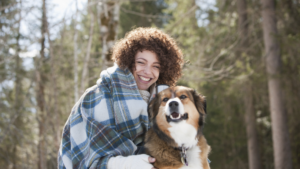 Young woman smiling with her dog outside