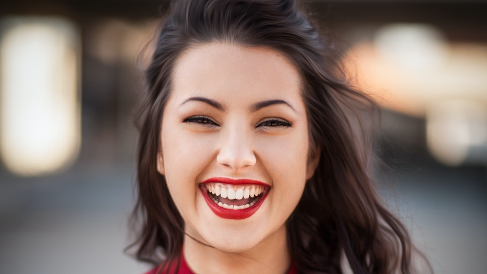 Young woman with bright red lipstick laughing