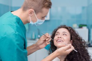 dentist or dental hygienist checking on patient's teeth